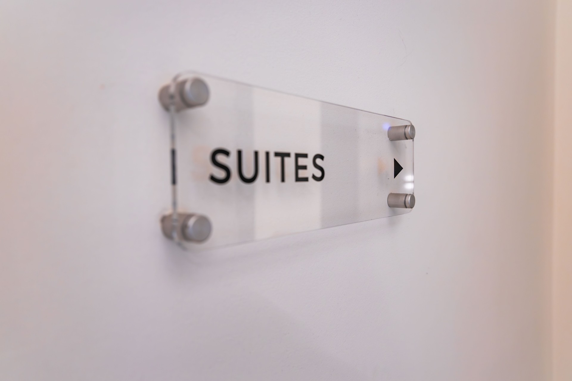 Modern Acrylic Sign with Suites Label and Arrow in Luxury Hotel